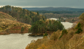 An island in a loch surrounded by trees and hills in autumn