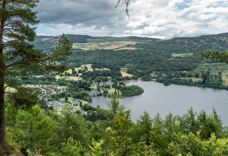 View of river Tay and a small village with trees on the hills