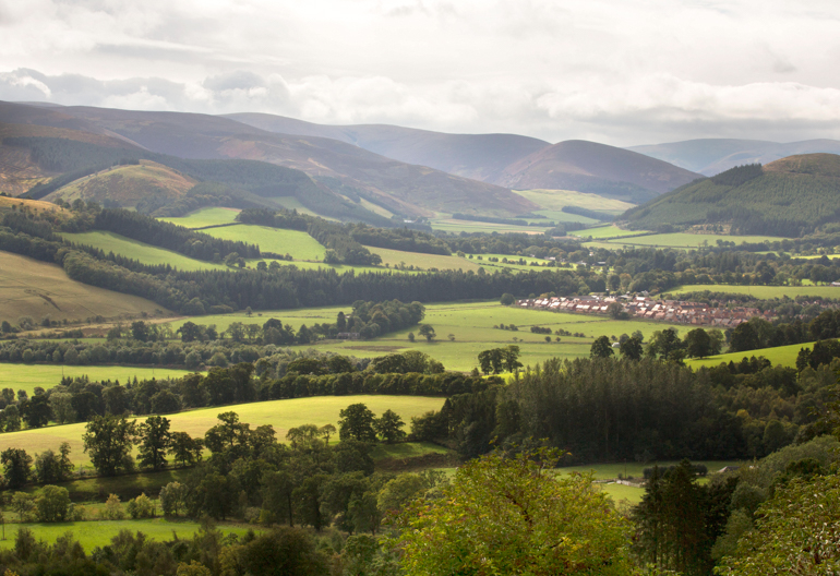 Hilltop view of fields, woodland and hills in Tweed Valley