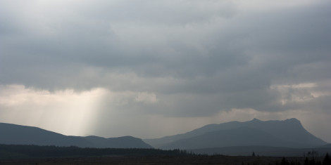 Silhouettes of hills and terrain against a cloudy sky at Borgie Glen