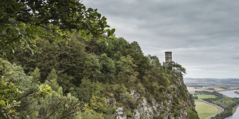 A distant view of Kinnoull Tower at Kinnoull Hill in Perthshire, with trees, cliffs and the River Tay visible.