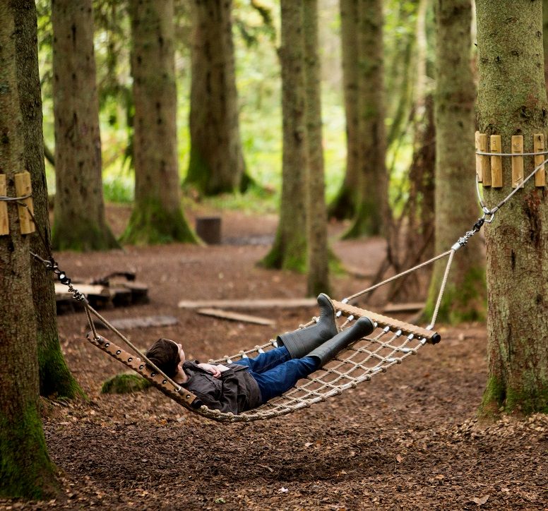 A boy resting in a hammock between two trees at The Lodge Visitor Centre