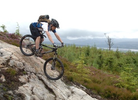 Mountain biker riding down a steep rock