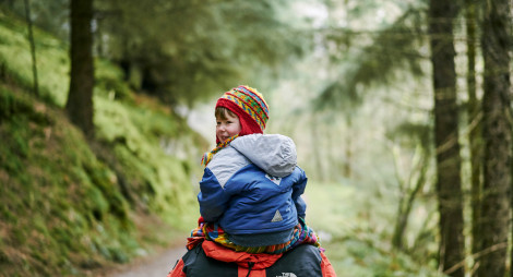 Child on parent's back walking through Daviot Wood