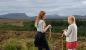 Two young girls stand together with Ben Loyal in background, Borgie Glen, Sutherland