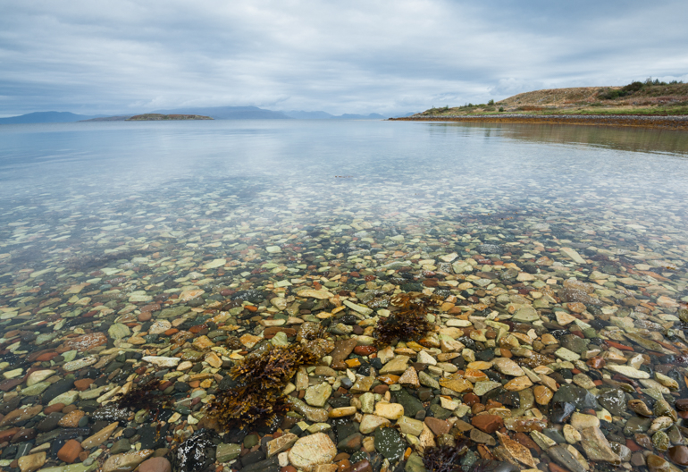  Looking down into the water at stones, rocks and seaweed at Broadford forest on the Isle of Skye