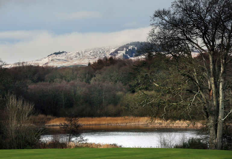 View over loch towards snow capped mountain, from Cally Woods, near Gatehouse of Fleet