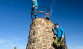 Two people at a narrow stone lookout tower