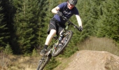 A mountain biker takes off from a trail jump