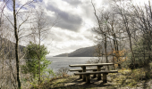 A wooden picnic table overlooking a loch
