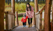 Woman and young boy walking across wooden bridge at Tentsmuir (near Leuchars) on forest trail
