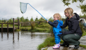 Young woman and toddler with fishing net at dipping platform, Newton Hill Croft, Wick, Caithness