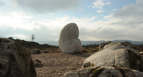 A heart shaped stone sculpture surrounded by boulders and smaller rocks