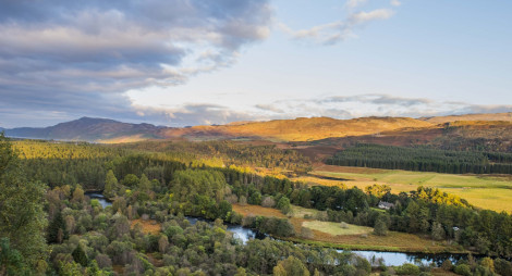 View from Torr Dhuin as golden evening sun spills across River Oich and surrounding mountain range, near Fort Augustus