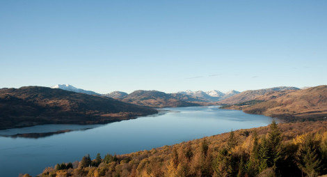 View over Loch Katrine to snow capped hills beyond