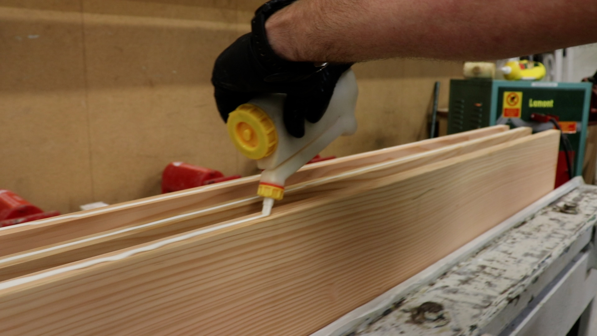 Person applying glue to wooden boards