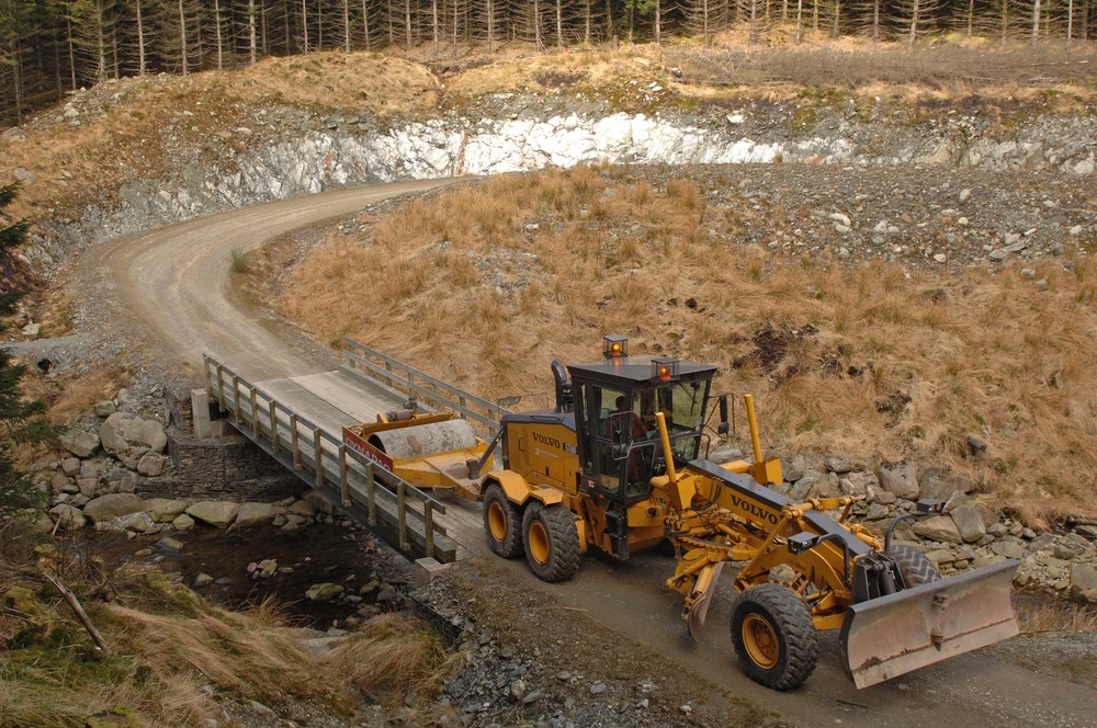 Construction equipment working on a road in a forest 