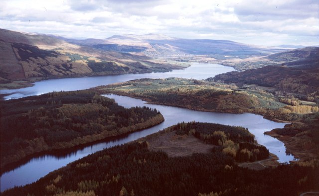 Aerial view of landscape containing multiple bodies of water and gentle hills with trees and open areas