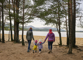 Two adults and two toddlers walking towards Loch Morlich Beach
