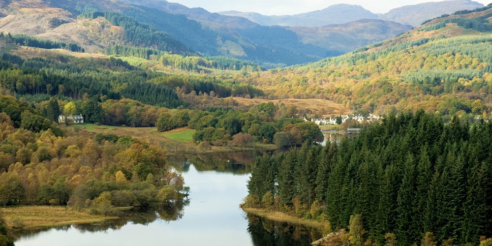 A view of Loch Ard with trees and hills on either side.