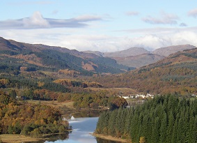 Loch Ard forest with river in the centre and trees and hills to either side