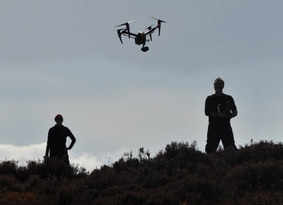 Two men flying a drone