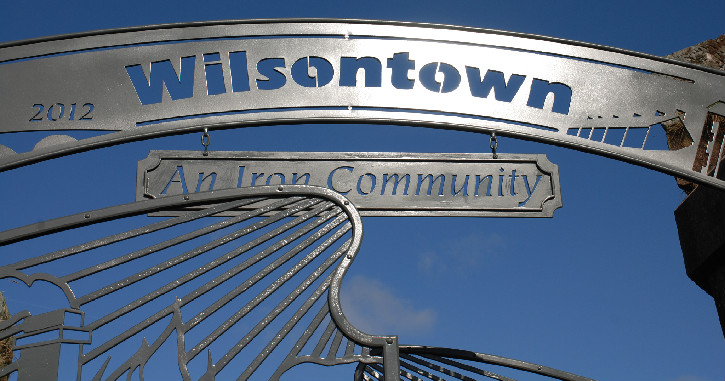 Large metal sign with blue sky beyond, reading Wilson Ironworks