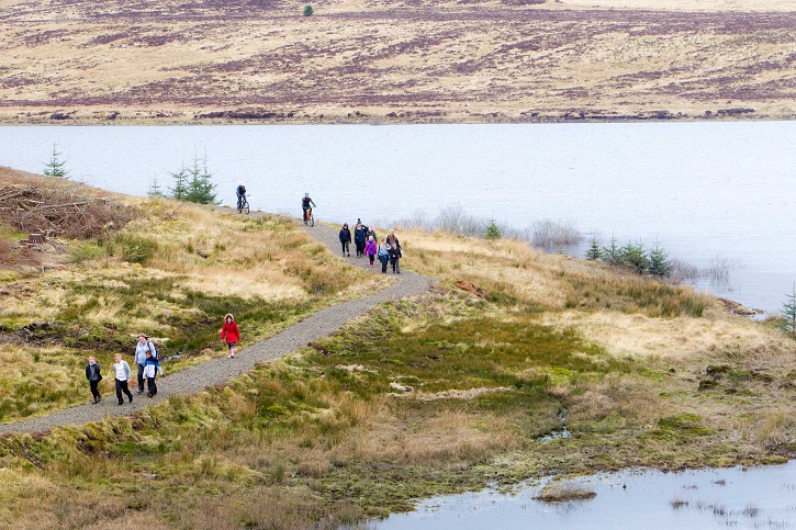 Groups of people walking along a section of the John Muir Way path.