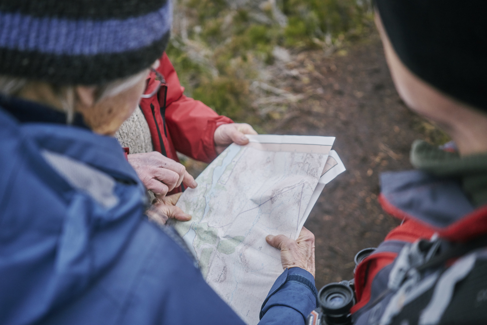 A close-up shot of three people looking at a map