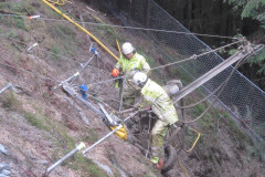 Two workers on a rock cliff in safety gear 