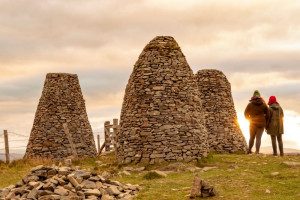 Three large stone cairns on a hilltop