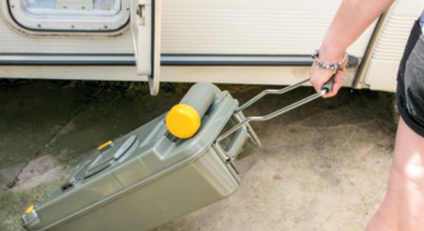 Person towing a waste water container from a motorhome