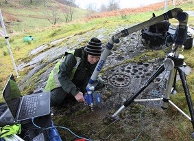 Archaeologist using a laser to scan carved rock art