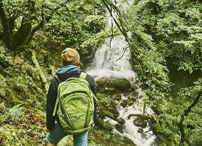 Person with back to camera looking at a waterfall
