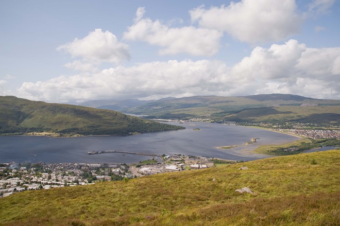 View over a large blue loch and grassy hillside