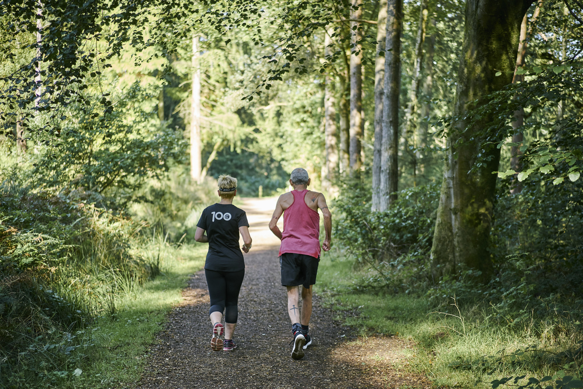 Two joggers on a forest path