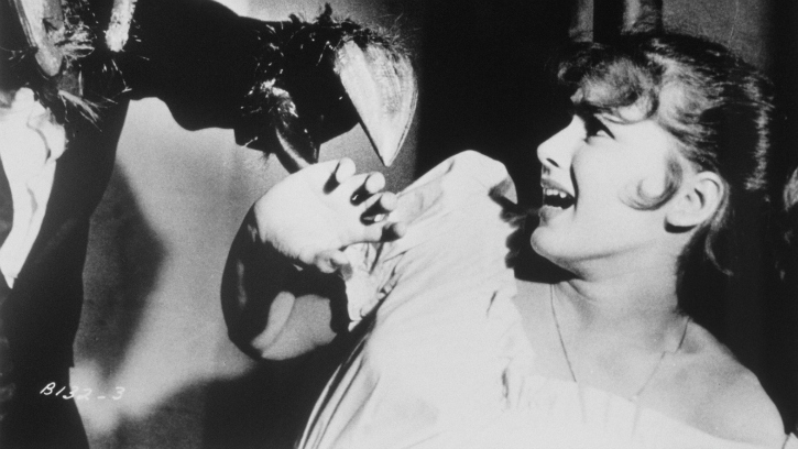 Still from a black and white film showing a human-sized insect terrorizing a woman