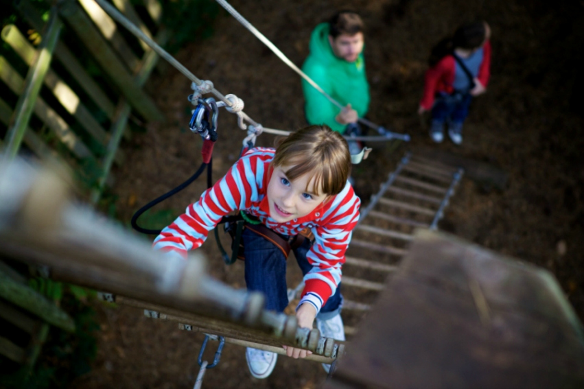 Young girl climbing a ladder at Go Ape Treetop Adventure