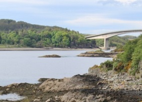 View across sea to forest next to the Skye Bridge
