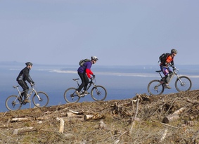 Three mountain bikers on the ridge of a hill