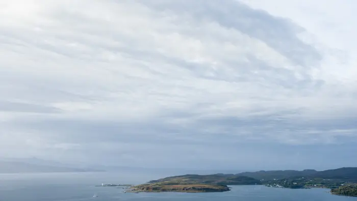 Blue sky with a headland in the the lower part of the image.