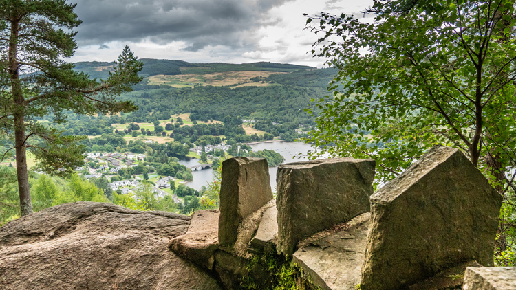 A stoned wall protecting a viewpoint looking over the river Tay with a village on the other side of the river