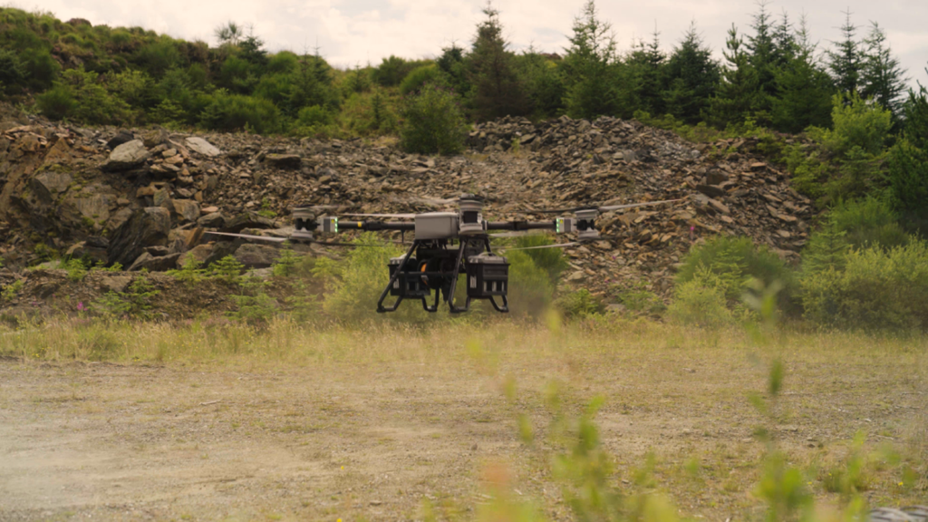 Heavy-lift drone taking off from an area of flat ground. 