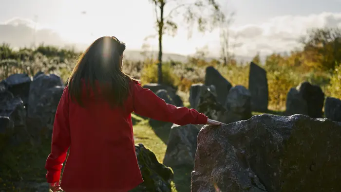 Person touching a stone in a maze.