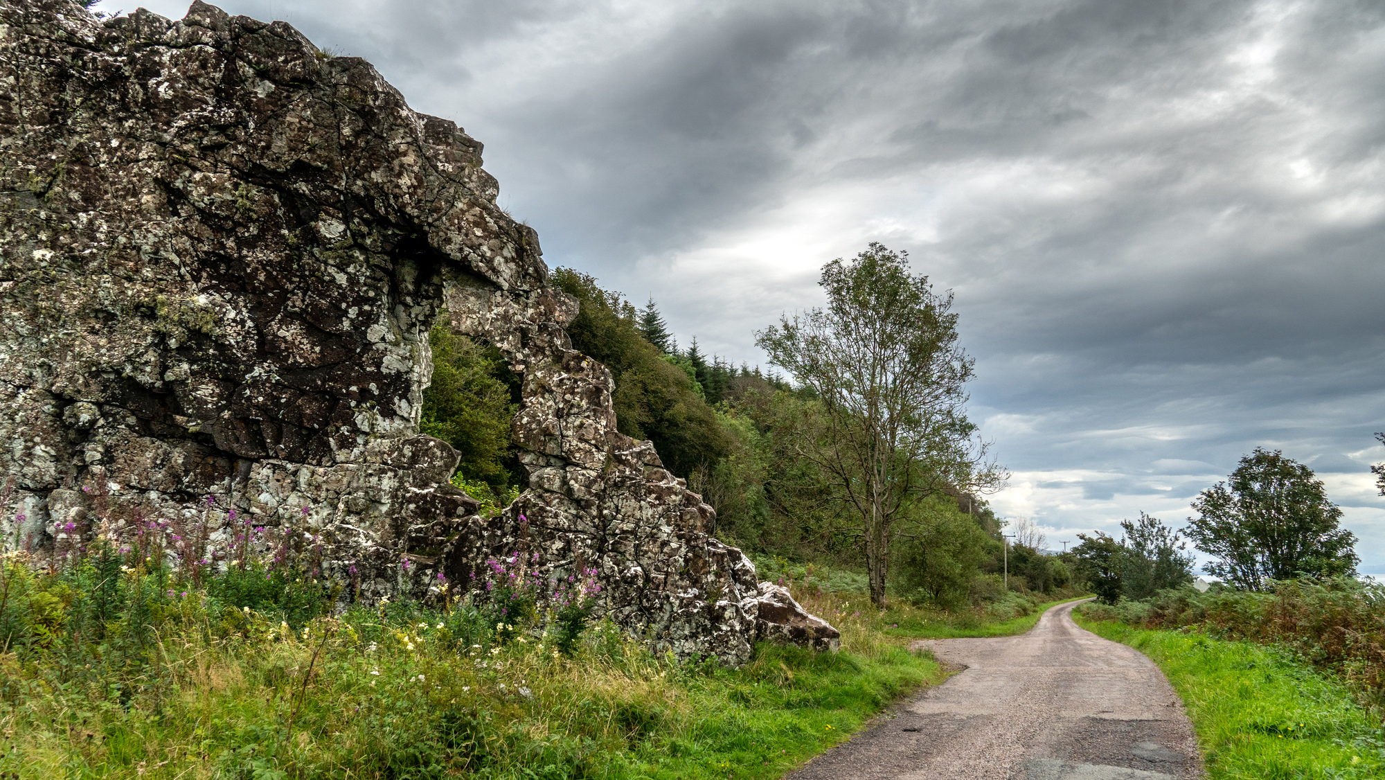 A stone rock formation next to the road