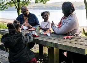 Family picnicking next to the sea