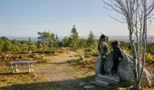 Man and teenage girl stand on open ground at Pulpit Rock, Tain Hill looking at panoramic views over Tarbet Ness