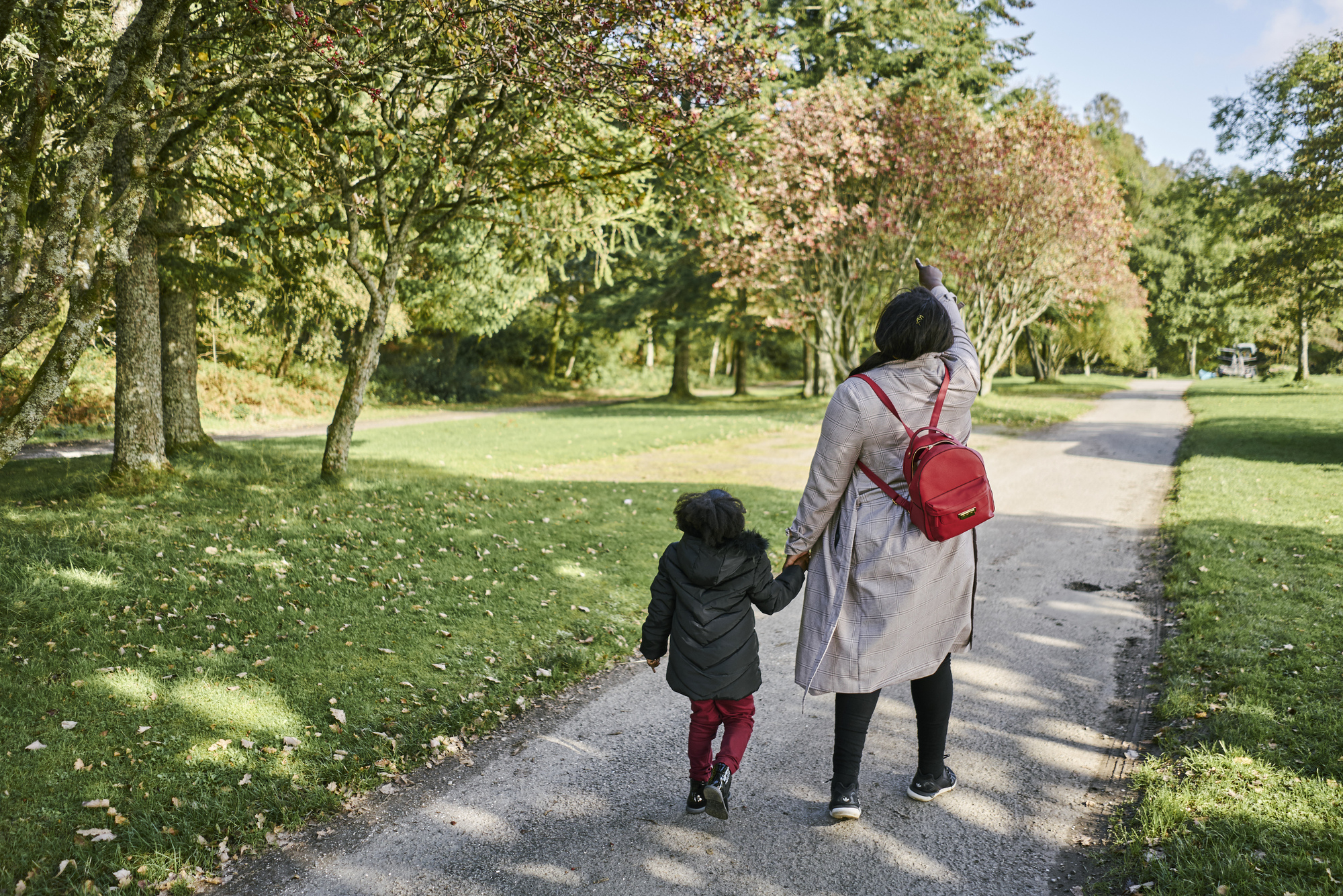  Woman and young girl walk together along path beside beach at Ardentinny, on the shore of Loch Long