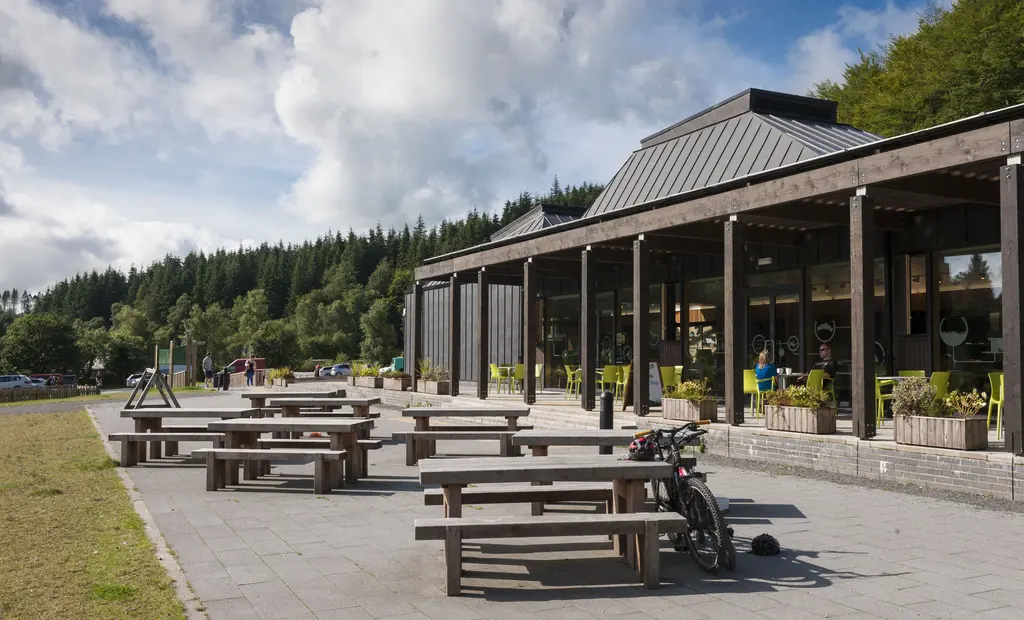 Kirroughtree Visitor Centre. Tables outside with the visitor centre in the background on a sunny day.