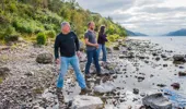 Two men and a woman skimming stones on south side shore of Loch Ness, near Change House